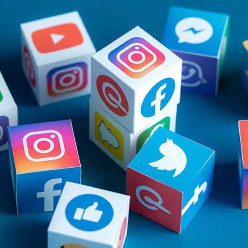 Cubes display various social media platform logos, including Instagram, Facebook, Twitter, YouTube, and Messenger, arranged on a blue background—perfect for showcasing the vibrant reach of a black-owned digital marketing agency in South Africa. - Proudly Developing